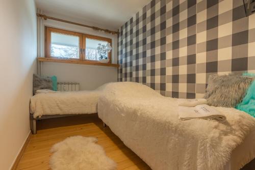 ein kleines Schlafzimmer mit 2 Betten und einem Fenster in der Unterkunft Apartament Lisowski CENTRUM in Zakopane