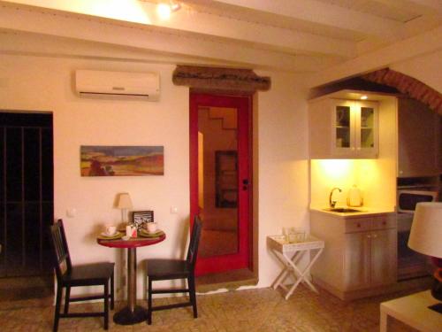 a room with a table and chairs and a kitchen at Casa da Rua Nova in Castelo de Vide
