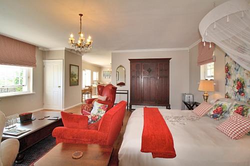 a large bedroom with a large bed with red furniture at Morton Manor in Somerset West