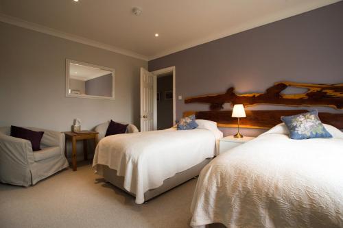 a hotel room with two beds and a chair at Sharamore House B&B in Clifden
