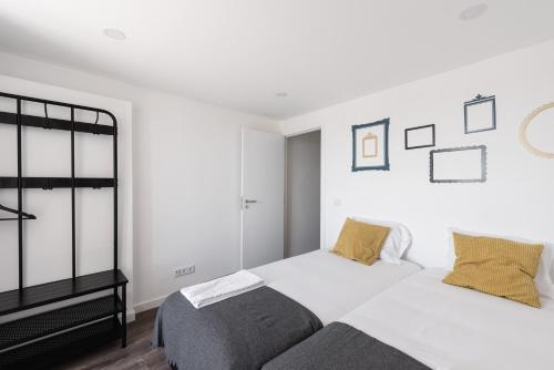 a bedroom with a bed, a desk, and a painting on the wall at City Stays Cais do Sodre Apartments in Lisbon