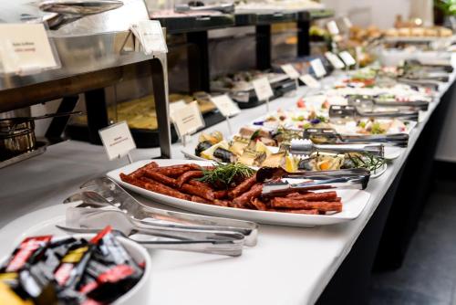 a buffet line with plates of food on a table at Hotel Villa Baltica in Sopot