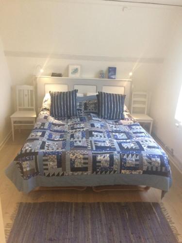 um quarto com uma cama com uma colcha em Steninge kuststation em Steninge
