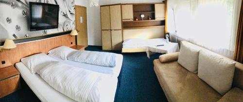 ein Hotelzimmer mit 2 Betten und einem Sofa in der Unterkunft Blackcoms Erika - Adults Only in Hahnenklee-Bockswiese
