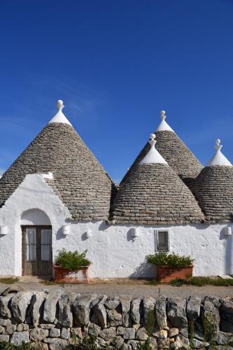 a white building with a thatched roof at B&B Trullo Barbagiullo in Cisternino