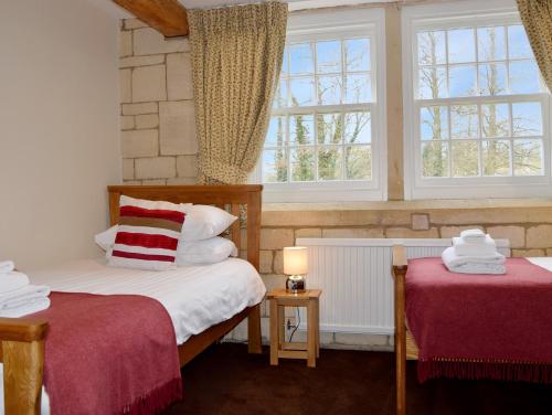 1 dormitorio con 2 camas y 2 ventanas en Lady Jane Grey, en Winchcombe
