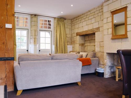 Una sala de estar con un sofá y una chimenea. en Lady Jane Grey, en Winchcombe