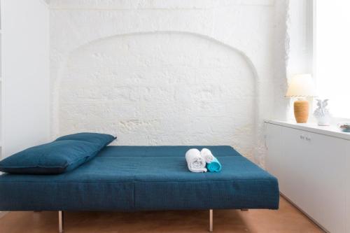 un letto con cuscini blu e asciugamani di Dimora Talenti Guest House a Polignano a Mare