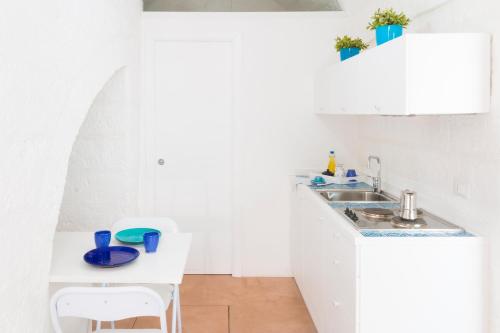 Una cocina blanca con fregadero y encimera. en Dimora Talenti Guest House, en Polignano a Mare
