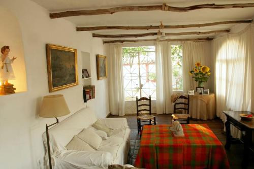 een woonkamer met een witte bank en een tafel bij Cortijo El Triguero N-398 Ctra Carmona – El Viso del Alcor Km 18 in Carmona