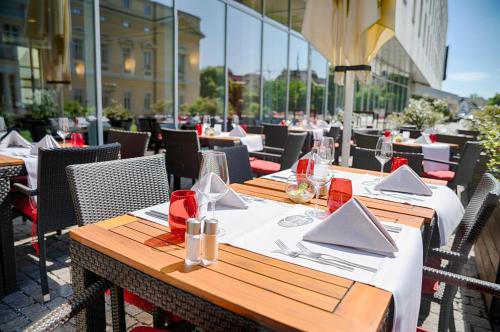 a table with napkins and glasses on a patio at Welcome Hotel Darmstadt City Center in Darmstadt
