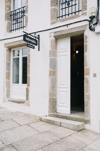 a white building with a door and a street sign at Inferniño Apartments in Santiago de Compostela