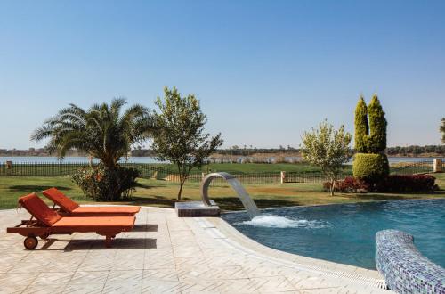 a swimming pool with a bench and a fountain at Jolie Ville Hotel & Spa Kings Island Luxor in Luxor