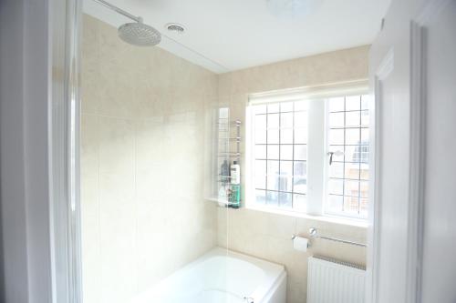 een badkamer met een bad, een toilet en een raam bij Entire Victorian Lodge in a privately gated estate with secure parking for two cars and a newly refurbished bathroom in Bath