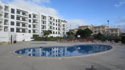 une piscine en face d'un grand bâtiment dans l'établissement Vista das Ondas, à Albufeira