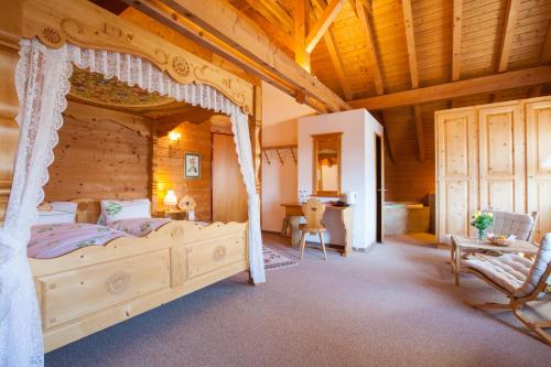 Dormitorio con cama con dosel en una cabaña en Hotel Restaurant Schönau, en Wildhaus