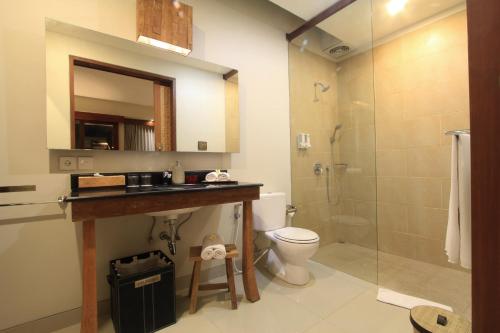 a bathroom with a sink and a toilet and a shower at Uma Karan in Seminyak