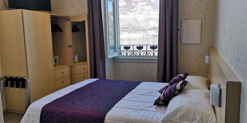 a bedroom with a large bed and a window at Hotel Helvetia in Lezzeno