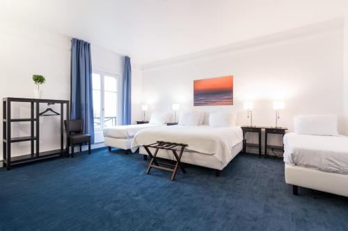 een hotelkamer met 2 bedden en een tafel bij Thermae Palace in Oostende
