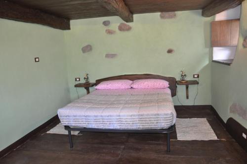 a bedroom with a bed with two pink pillows at Il Borgo Di Monica in Domodossola