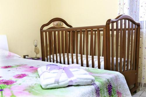 a crib with a pink and white blanket on it at B&B Le Magnolie in Amorosi