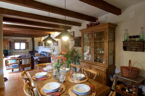 a dining room with a wooden table and chairs at La Covarxella in Culla