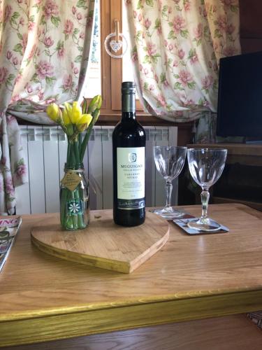 a bottle of wine sitting on a table with glasses at Log home village in Ulverston