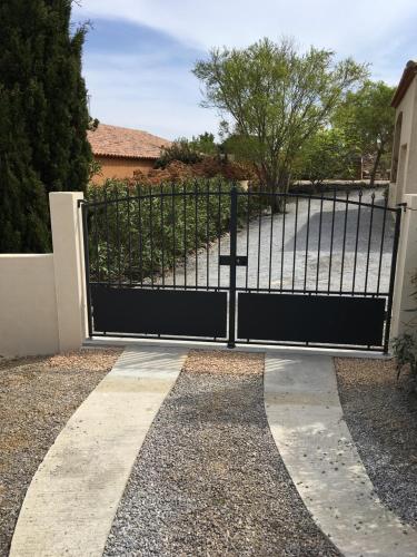 a black gate in front of a driveway at La villa marquesa in Fitou