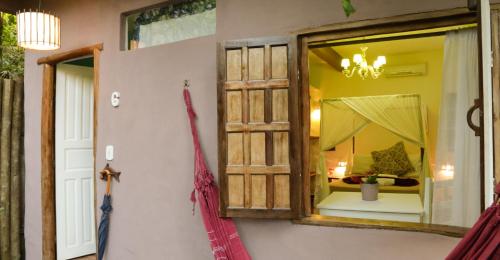 un espejo en una pared junto a una habitación en Pousada Raízes do Brasil, en Trancoso