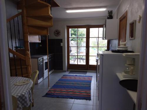 a kitchen with a refrigerator and a table and a window at Le Patronage in Bazoges-en-Pareds
