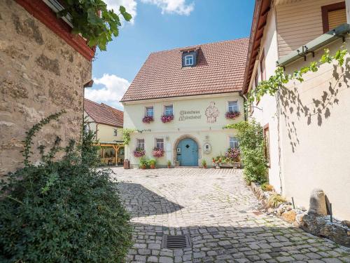 a building with a blue door in a courtyard at Gästehaus Mönchshof in Sommerhausen