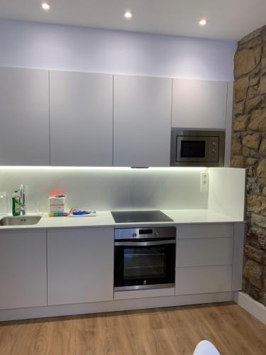 a kitchen with white cabinets and a stove top oven at OLA Apartamento - Perla Boutique Apartamentos in Donostia-San Sebastián
