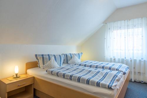 ein Schlafzimmer mit einem Bett mit blau-weißer Bettwäsche in der Unterkunft Haus Kleemann in Norderney