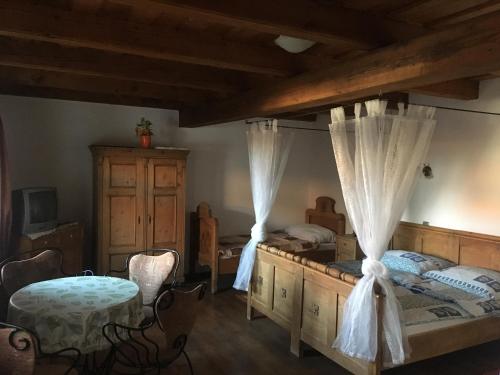 1 dormitorio con 2 camas, mesa y sillas en HoMe Vendégház, en Ganna