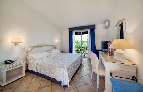 - une chambre avec un lit, un bureau et une télévision dans l'établissement Grand Hotel In Porto Cervo, à Porto Cervo