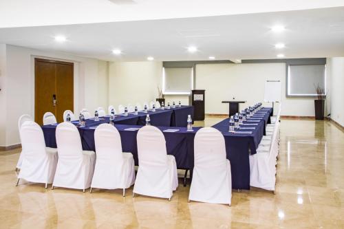 a conference room with blue tables and white chairs at Imperio de Angeles Executive León Poliforum in León