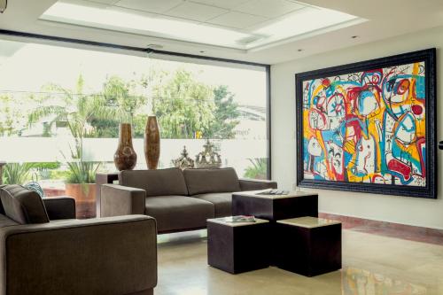 a living room with a couch and a painting on the wall at Imperio de Angeles Executive León Poliforum in León