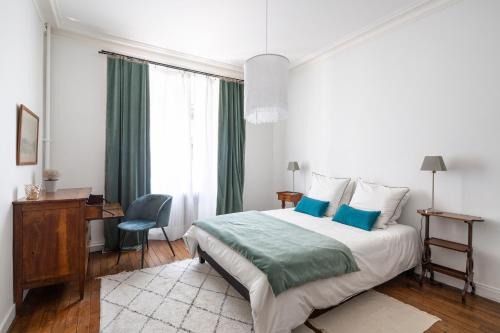 - une chambre blanche avec un lit, un bureau et une chaise dans l'établissement LE RECIT by Cocoonr, à Rennes