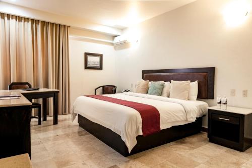 Habitación de hotel con cama y escritorio en Imperio de Angeles Executive León by Real de Minas Business Class, en León