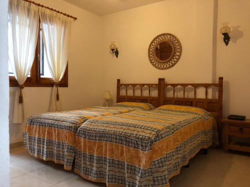 Un dormitorio con una cama y un espejo en la pared. en Appartment Teneriffa Tamara Anlage, en Santiago del Teide