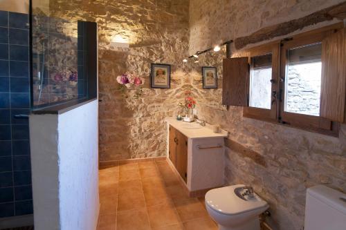 a bathroom with a toilet and a sink and a window at La Covarxella in Culla