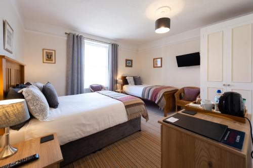 a hotel room with two beds and a television at Blue Swallow in Penrith