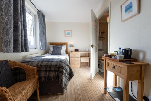a bedroom with a bed and a desk and a chair at Blue Swallow in Penrith