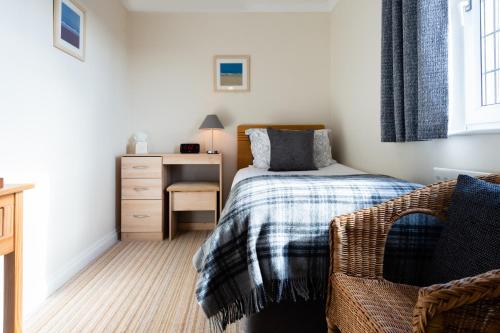 a small bedroom with a bed and a desk at Blue Swallow in Penrith