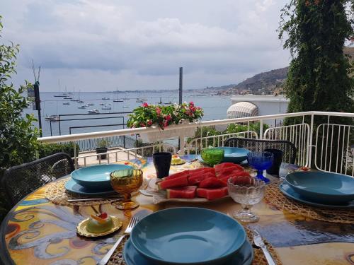 a table with plates of food on top of a balcony at Blue Lagune Taormina Mare in Taormina