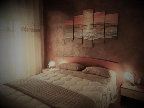 a bedroom with a bed and two paintings on the wall at Casa&Mare in Pizzo