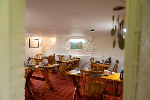 uma sala de jantar com mesas e cadeiras de madeira em Blue Swallow em Penrith