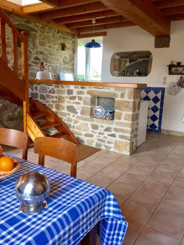 - une cuisine avec une table et une cheminée en pierre dans l'établissement la maison perchée, à Le Vast
