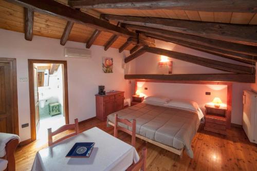 - une chambre avec un grand lit et une table dans l'établissement Agriturismo Domus Rustica, à Cormòns