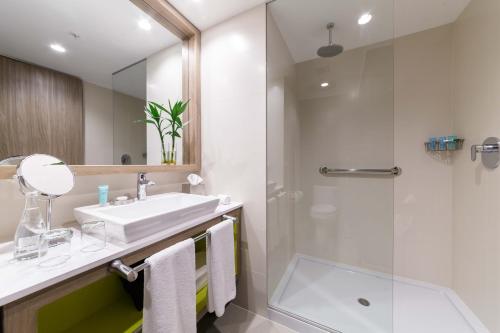 a bathroom with a sink and a shower at INNSiDE by Meliá Lima Miraflores in Lima